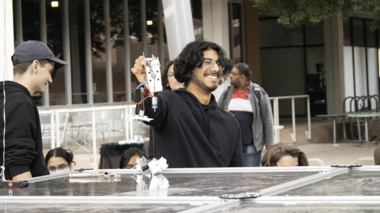 Alejandro Gonzalez Gutierrez, a mechanical engineering junior and Combat Ready Robotics workshop co-director, shows off the remains of his robot at the Sun Devil Smackdown.